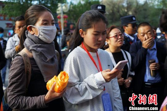 图为6月7日，手持哈达的家长到拉萨中学考点外陪考生候场。　张伟 摄