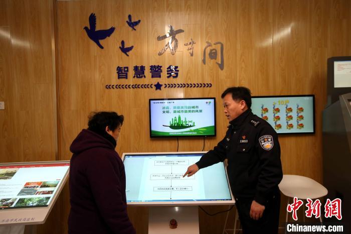 图为民警在智慧警务平台指导居民如何在网上查询信息。　受访单位供图 摄